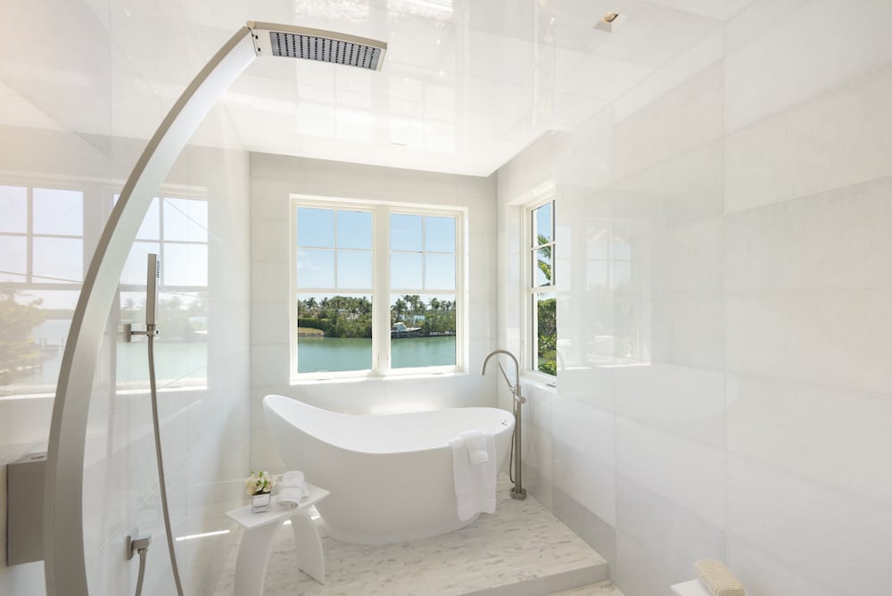 white bathroom with a bathtub overlooking the water