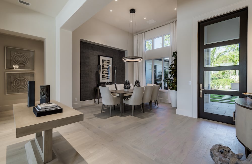 dining room with white chairs surrounding it, located by the front door