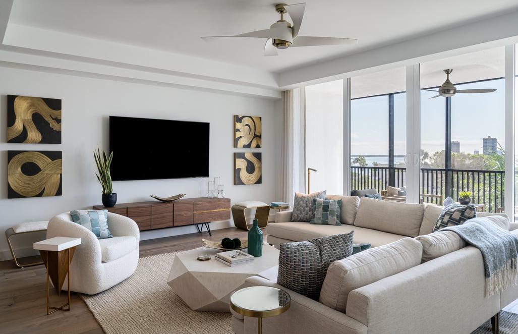 interior of a living room with a sectional facing towards a large flat screen TV
