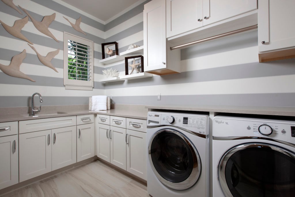 The laundry room of this custom home features floating shelves to display accessories