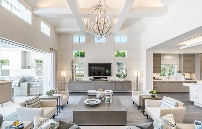 living room with white couches and chairs with a big tv as the focal point