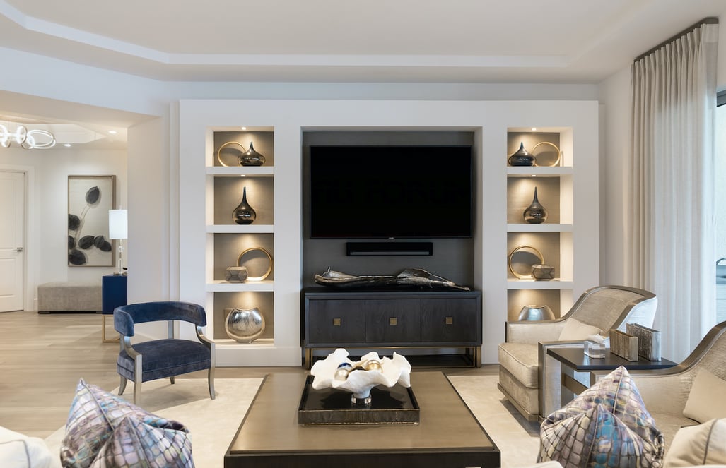 living room with brown and gold accents facing a large TV