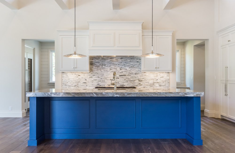 kitchen with a blue base counter and multicolored backsplash