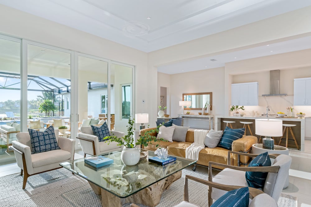 living room with couch that has coastal blue accents and glass coffee table